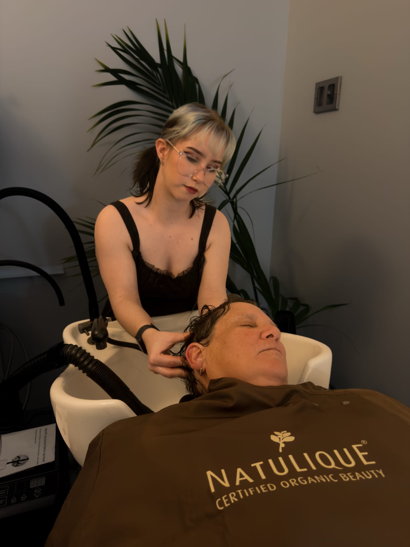 A guest relaxing at the basin during a scalp and hair treatment at About Hair Mackay